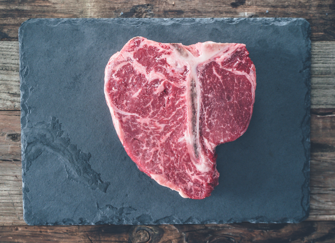 Overhead of huge prime porterhouse steak with rich marbling