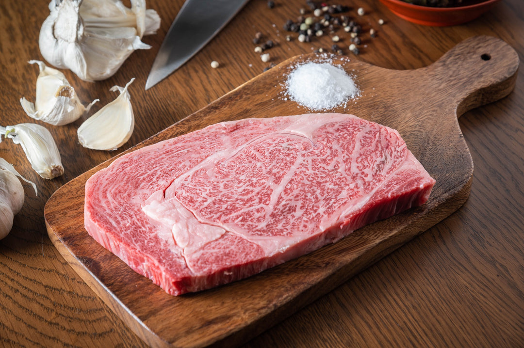 Richly marbled Japanese wagyu rib eye ready to be seasoned with salt, pepper, and garlic